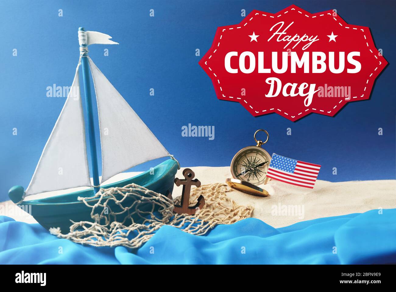 Text HAPPY COLUMBUS DAY with wooden boat and net on blue background. National holiday concept. Stock Photo