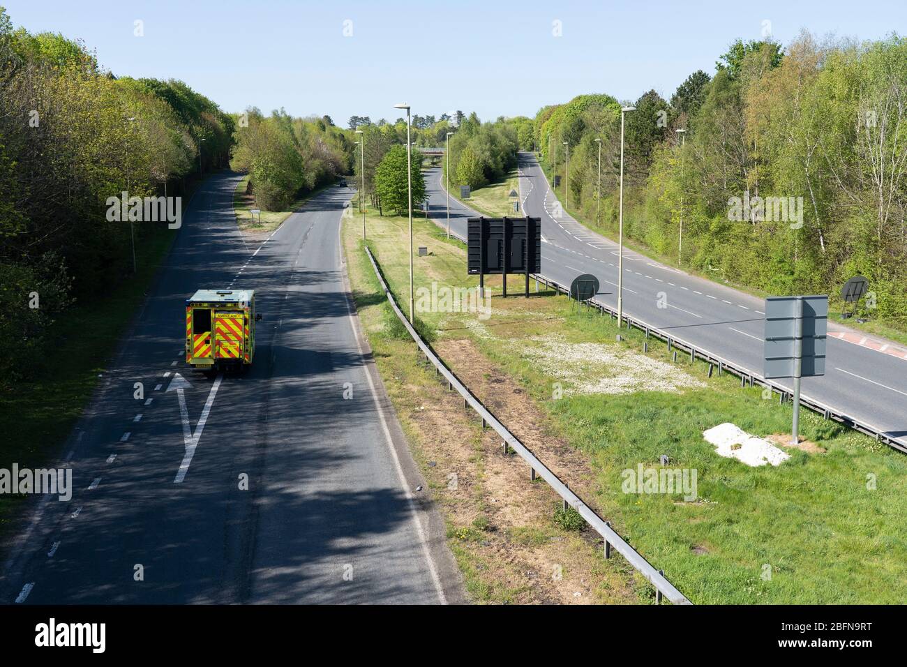 An ambulance driving down an otherwise empty dual carriageway in Basingstoke during the Coronavirus Covid 19 pandemic, April 2020, UK Stock Photo