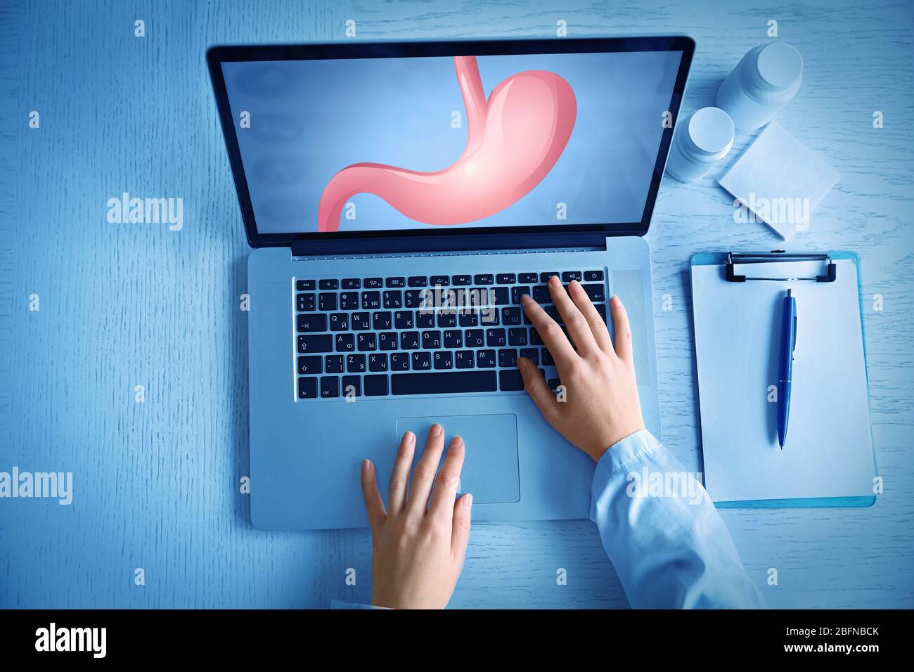 Doctor with laptop, closeup. Stomach on screen. Medicine and modern