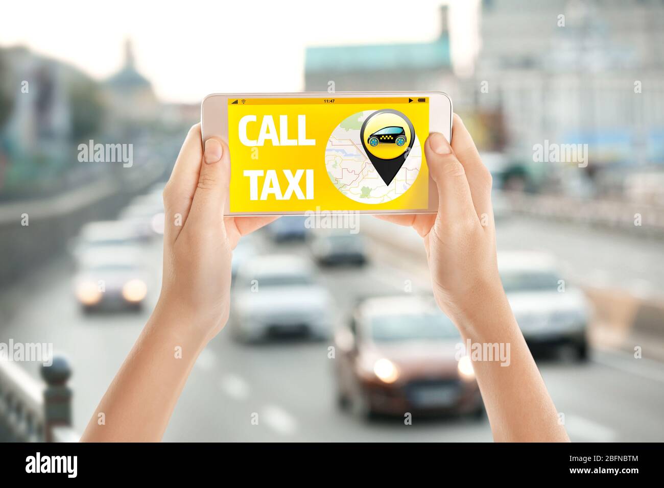 Female hands with smartphone on cityscape background. Taxi service application on screen. Stock Photo