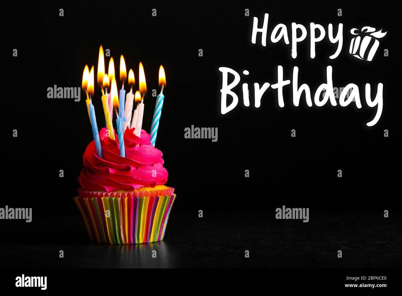 Cupcake with candles and text HAPPY BIRTHDAY on black background Stock  Photo - Alamy