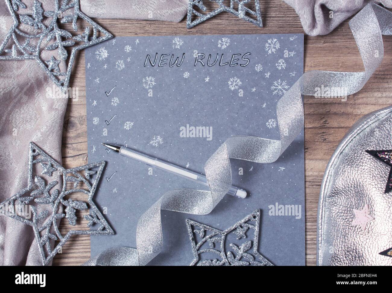 Words and patterns on gray paper. New year, new rules. Motivation, plan, schedule, task, new life. Christmas, holiday. Snowflakes and Christmas toys. Stock Photo