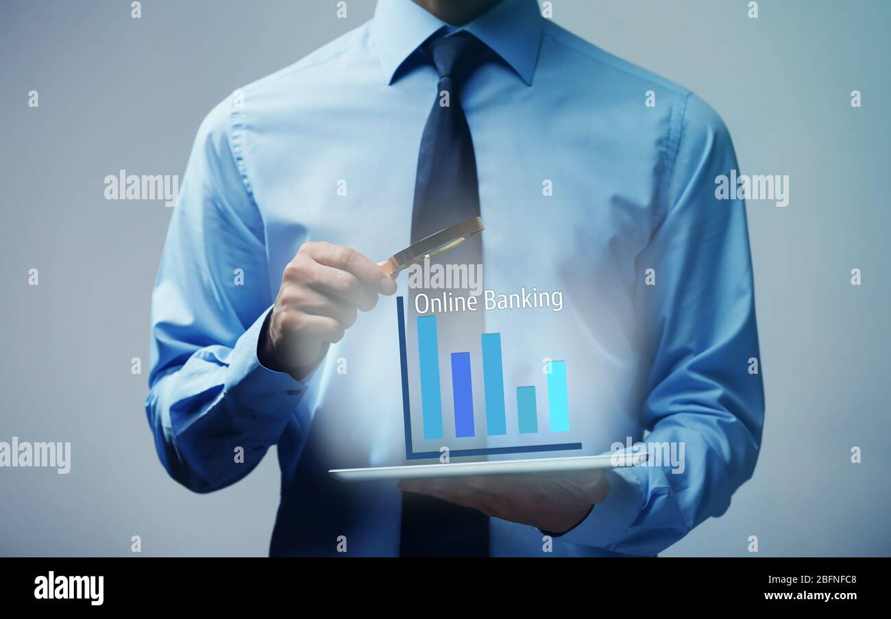 Online banking concept. Man using tablet and magnifier Stock Photo