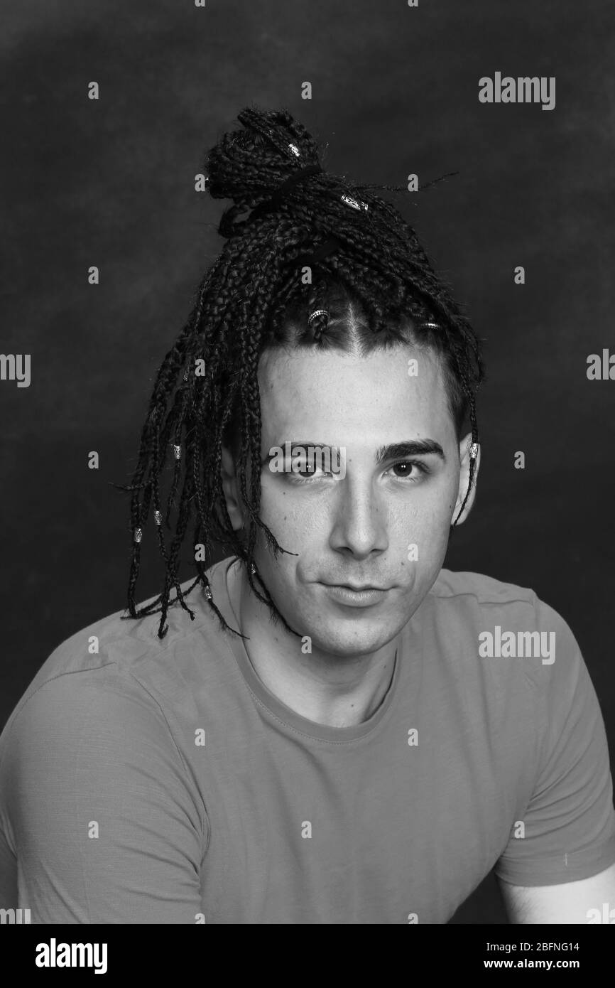 Stylish male model with afro braids posing in studio on isolated
