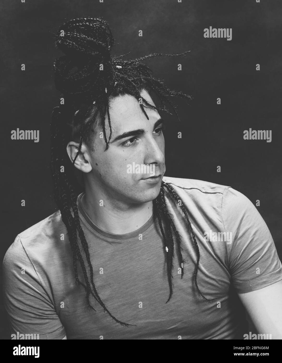 Stylish male model with afro braids posing in studio on isolated