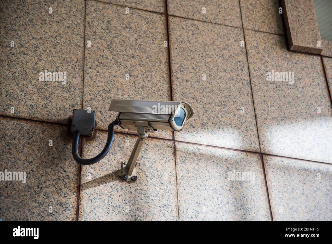 Urban security camera on the wall Stock Photo