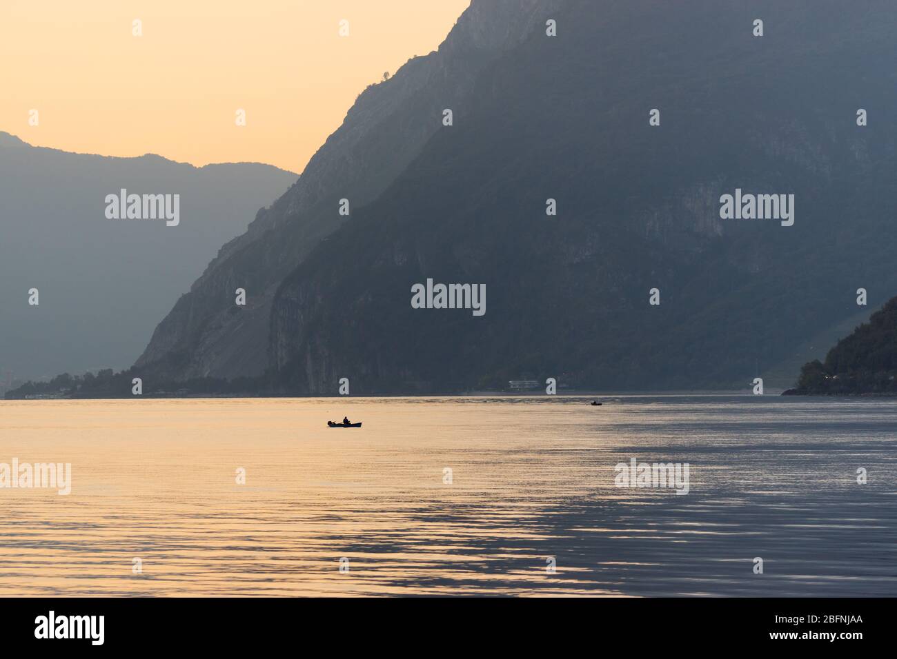 Two boats sailing at the calm waters of lake Como, northern Italy. Early morning at the end of September 2019. Stock Photo