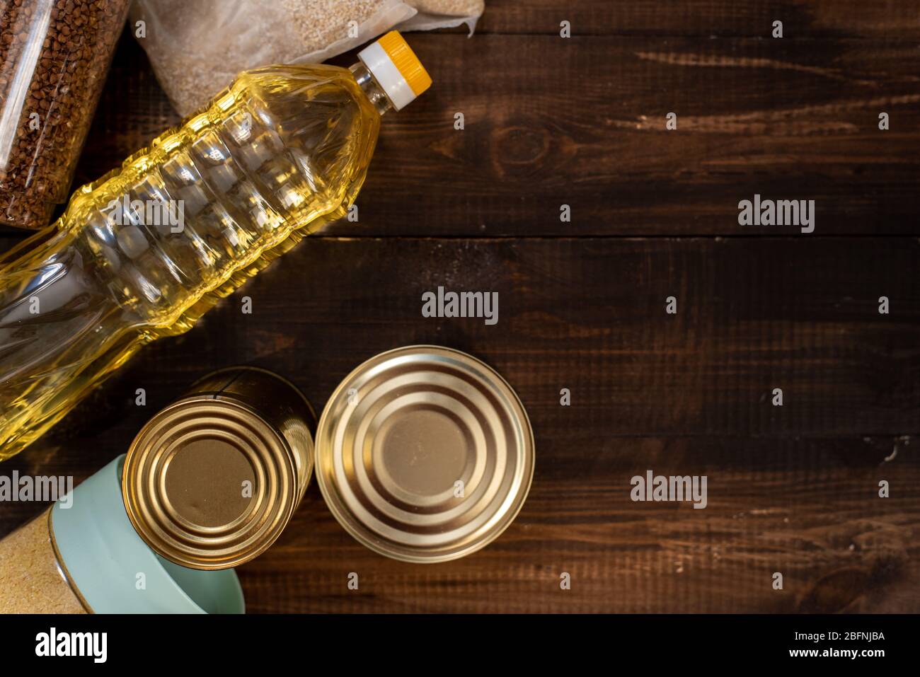 Cereals, various products, canned food, pasta and soap on a wooden background with place for text. Humanitarian assistance during the coronavirus pand Stock Photo