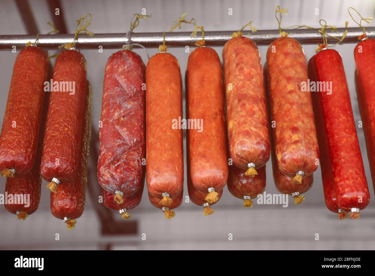 Assortment of sausages hanging on rack at market Stock Photo - Alamy