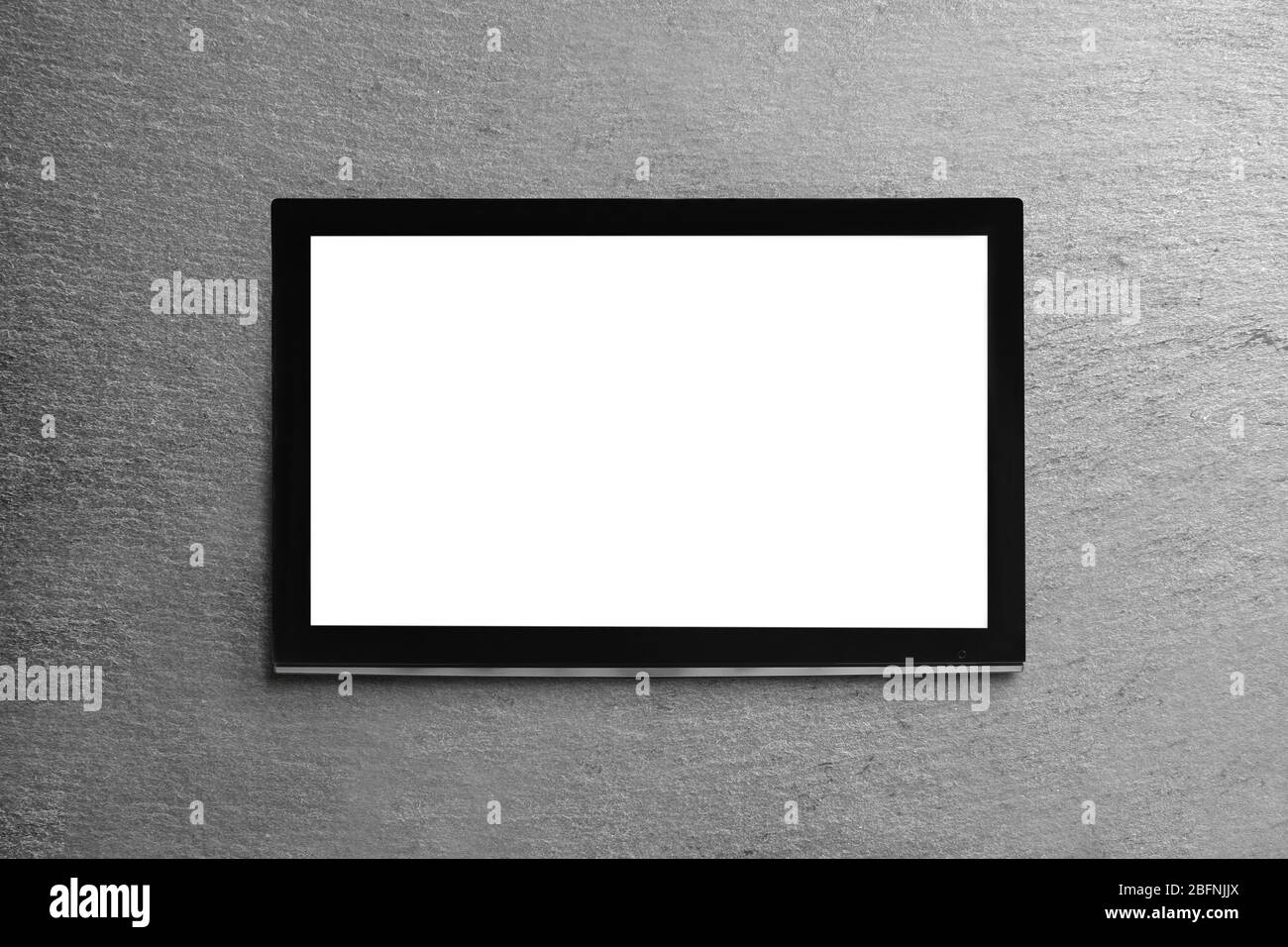 Modern TV screen on grey wall background Stock Photo - Alamy