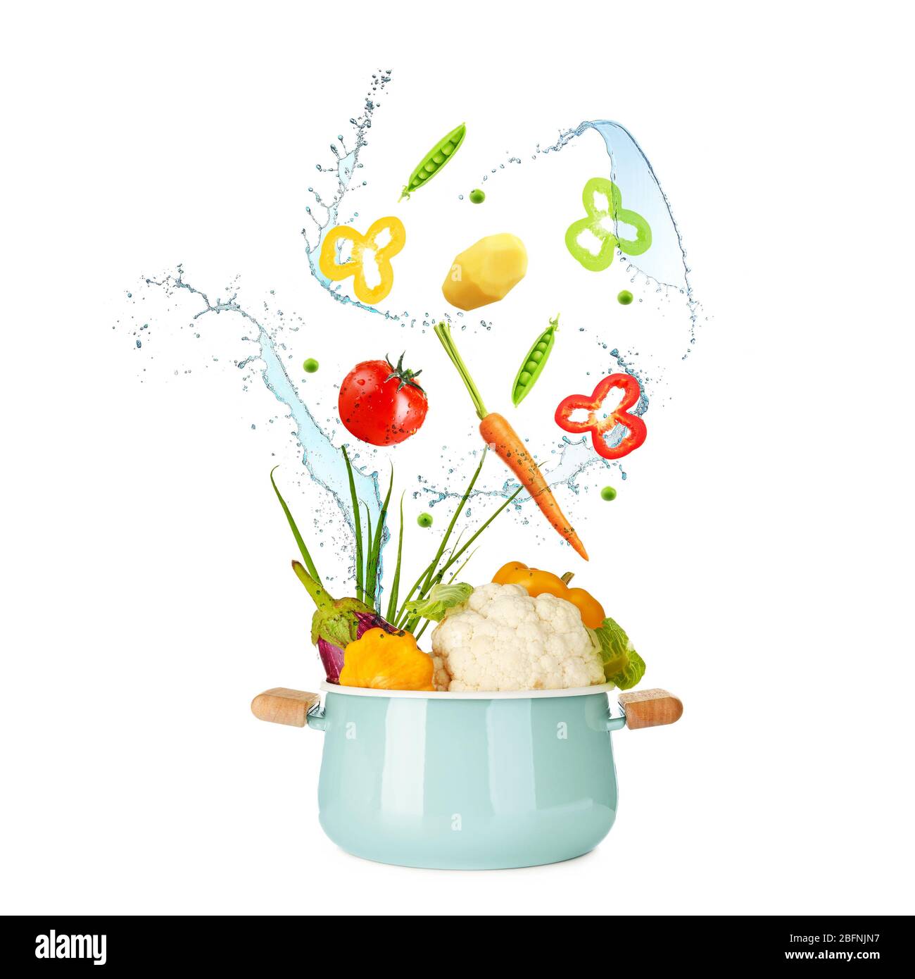 Different vegetables, water splashes and saucepan on white background Stock Photo