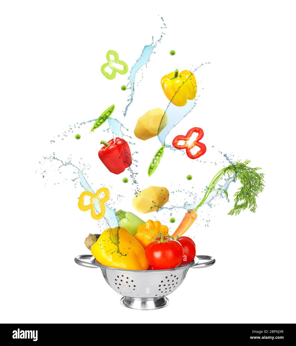 Different vegetables, water splashes and colander on white background Stock Photo