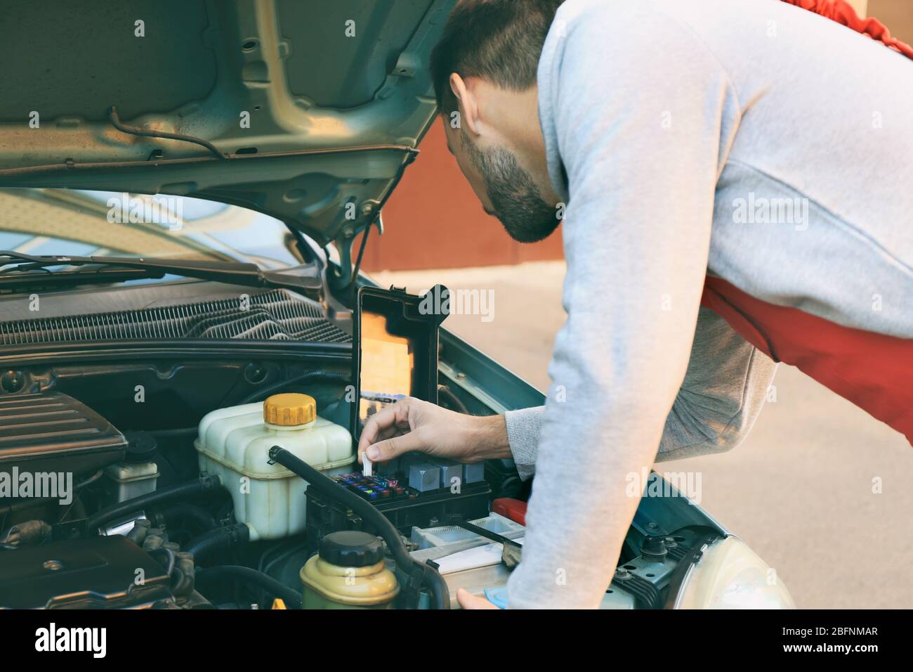 Auto mechanic repairing car at service station Stock Photo