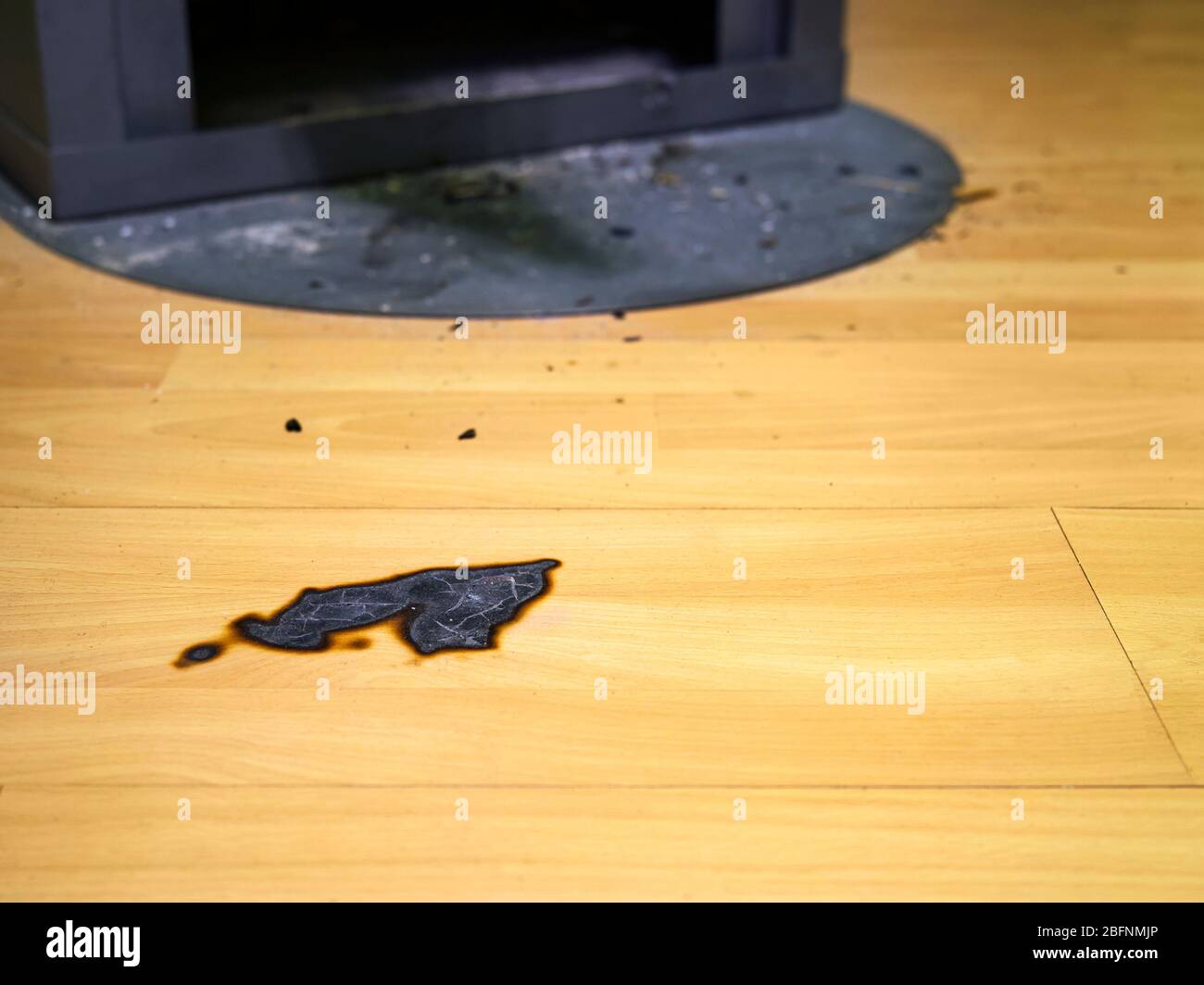 A piece of wood fell out of the fireplace and burned the floor Stock