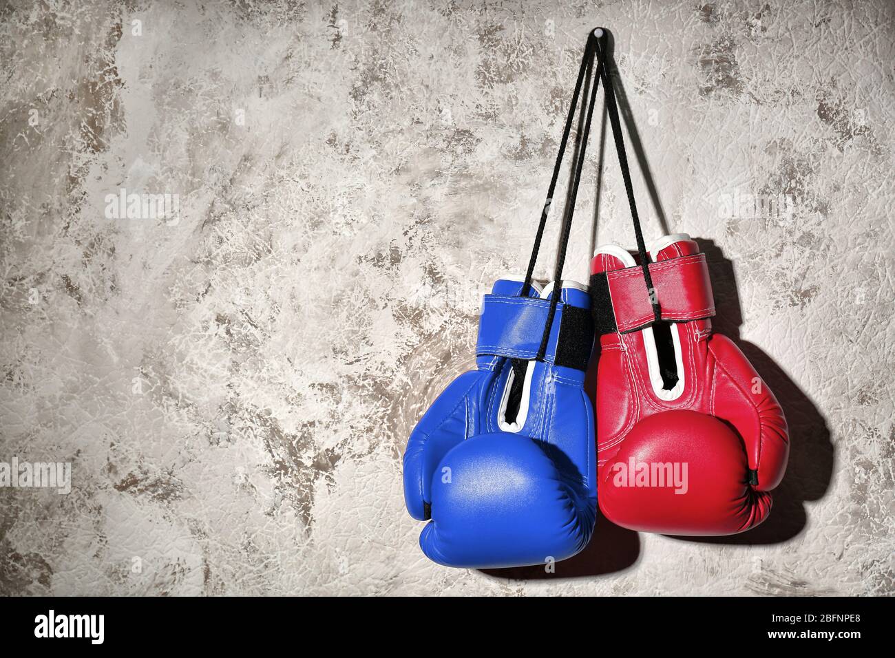 Red and blue boxing gloves hanging on wall. Concept of political
