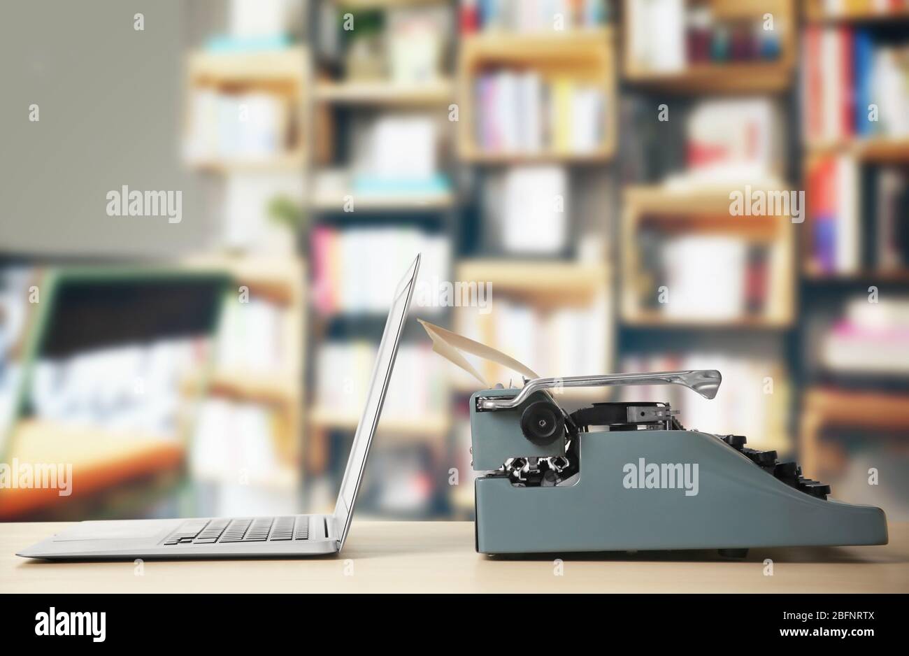 Old typewriter and laptop on table at library Stock Photo