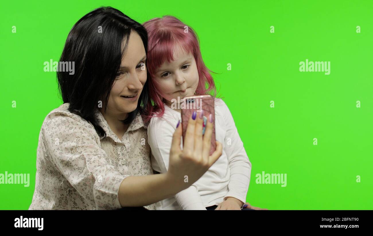 Cute funny little kid girl having fun with mom enjoy using modern ...