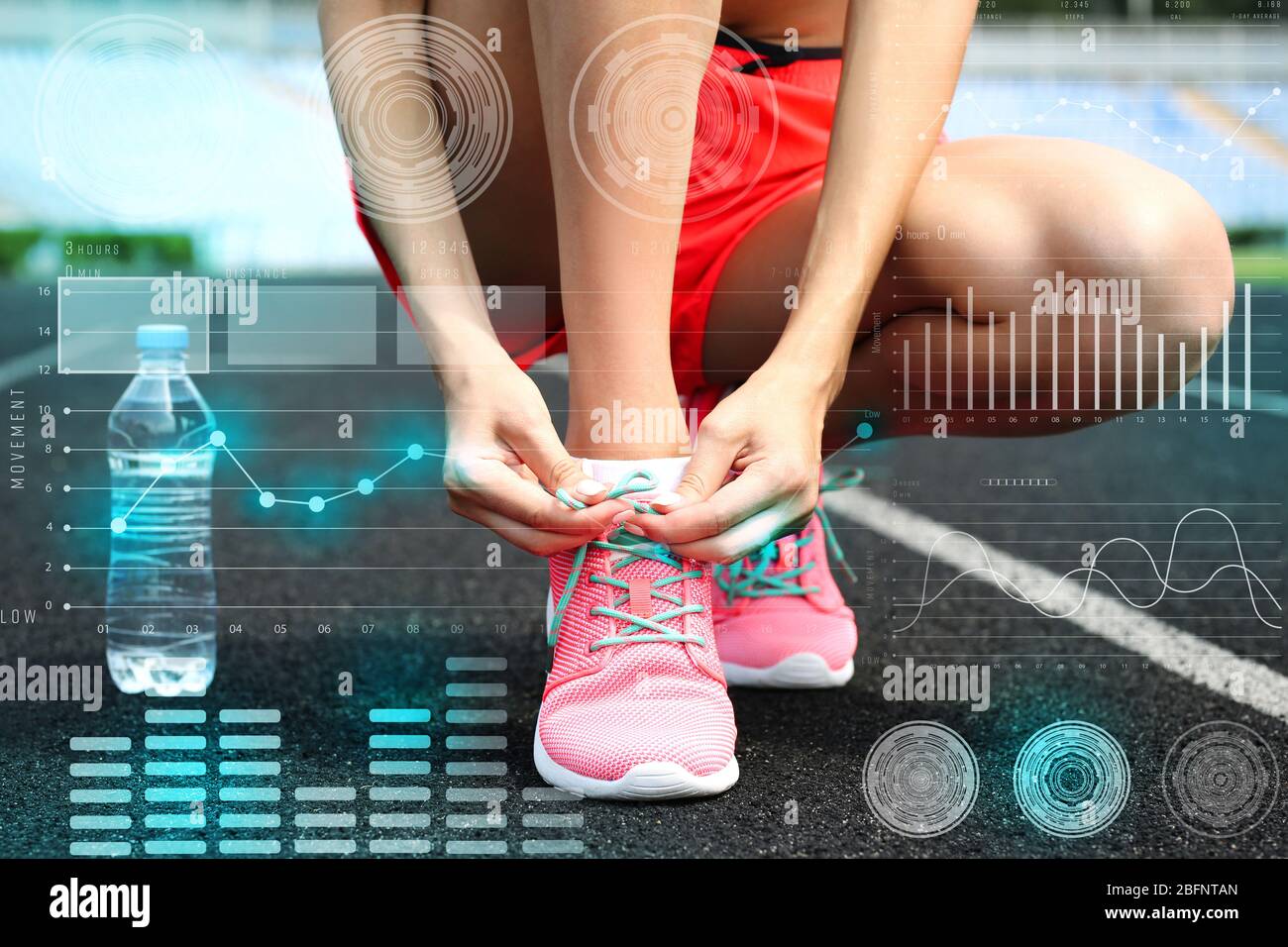 Heart rate monitor concept. Young woman tying shoelaces on morning run Stock Photo
