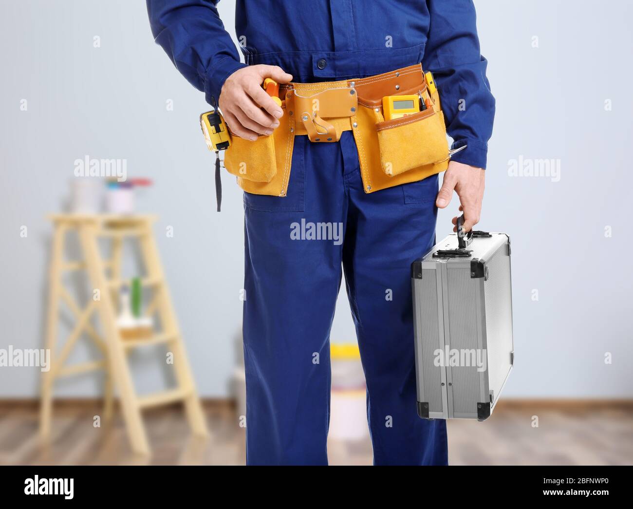 Electrician with tools on blurred background Stock Photo