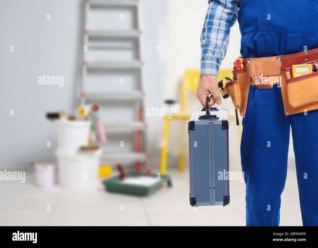 Electrician with tools on blurred background Stock Photo