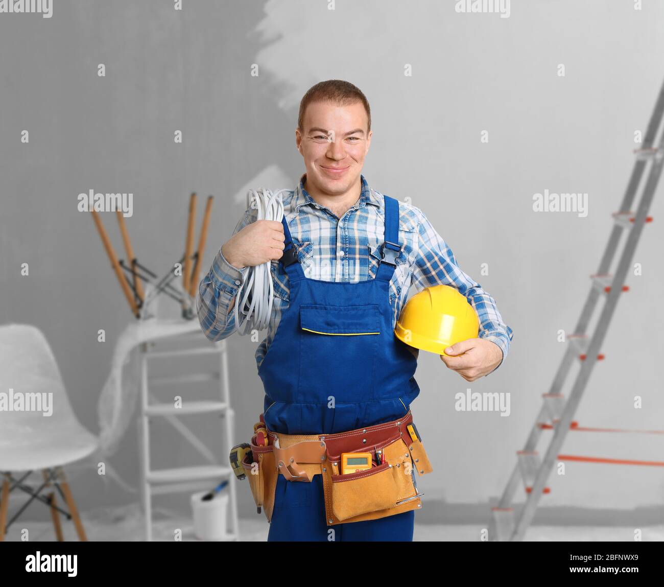 Electrician with tools at new house Stock Photo