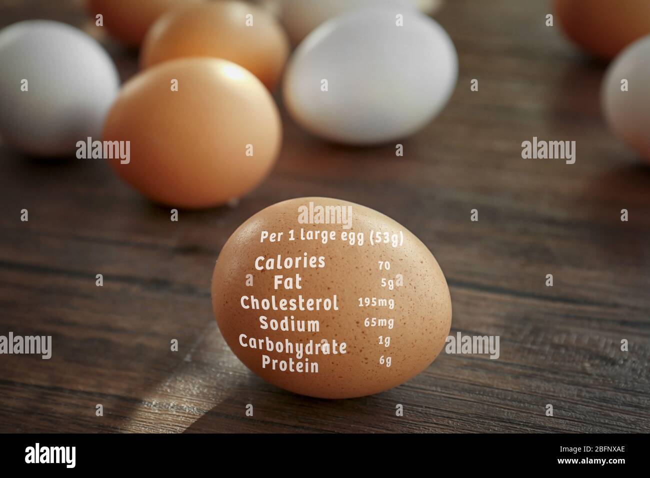 Raw egg and list of nutrition facts on wooden background Stock Photo