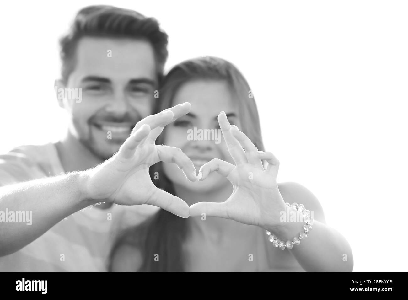 Beautiful young couple holding hands in shape of heart Stock Photo - Alamy