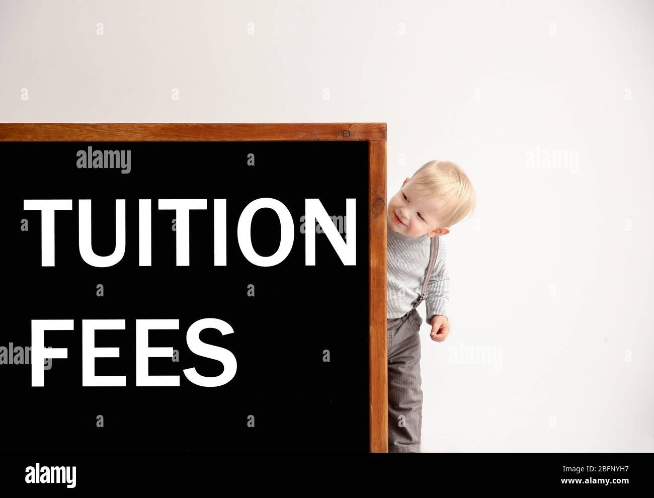 Cute little boy and blackboard with text TUITION FEES on light background  Stock Photo - Alamy