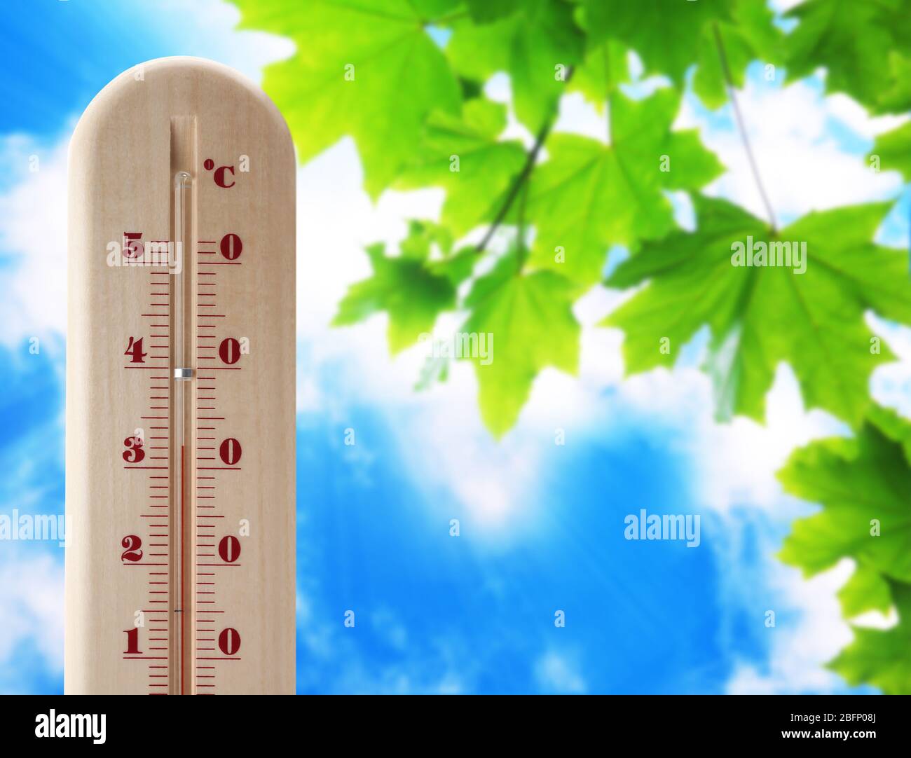 Wooden thermometer with red measuring liquid showing high temperature over  32 degrees Celsius on background of blue sky with clouds. Concept of heat w  Stock Photo - Alamy