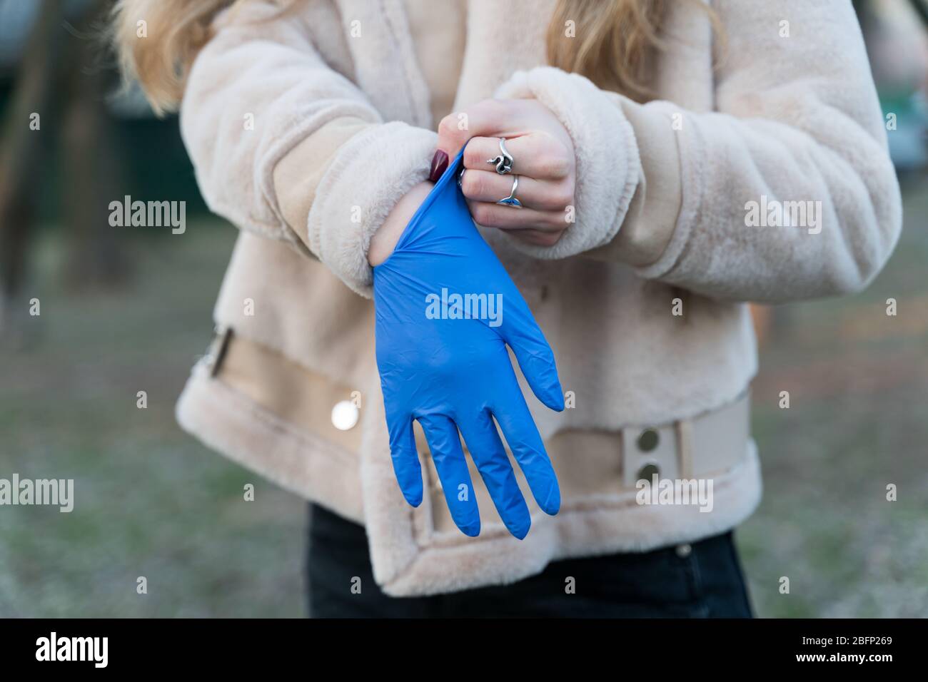 girl puts on disposable gloves outdoors Stock Photo Alamy