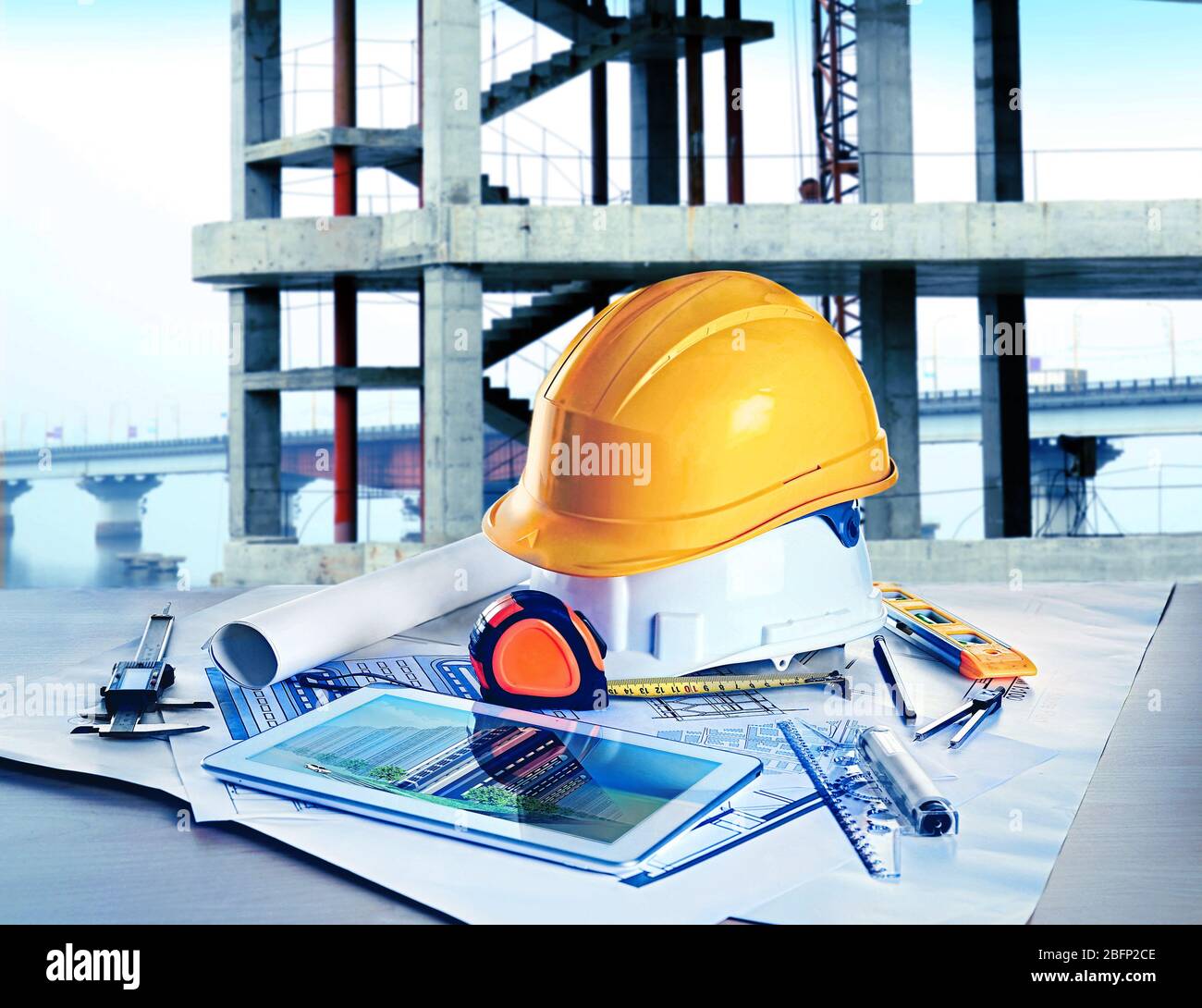 Table with construction drawings and other tools on unfinished building ...
