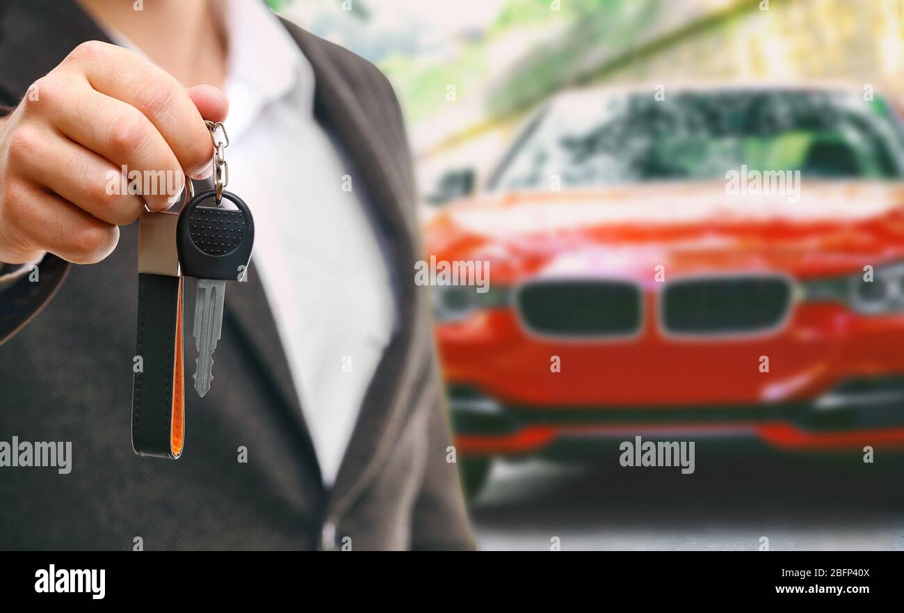 Businessman holding car key on blurred red car background Stock Photo ...