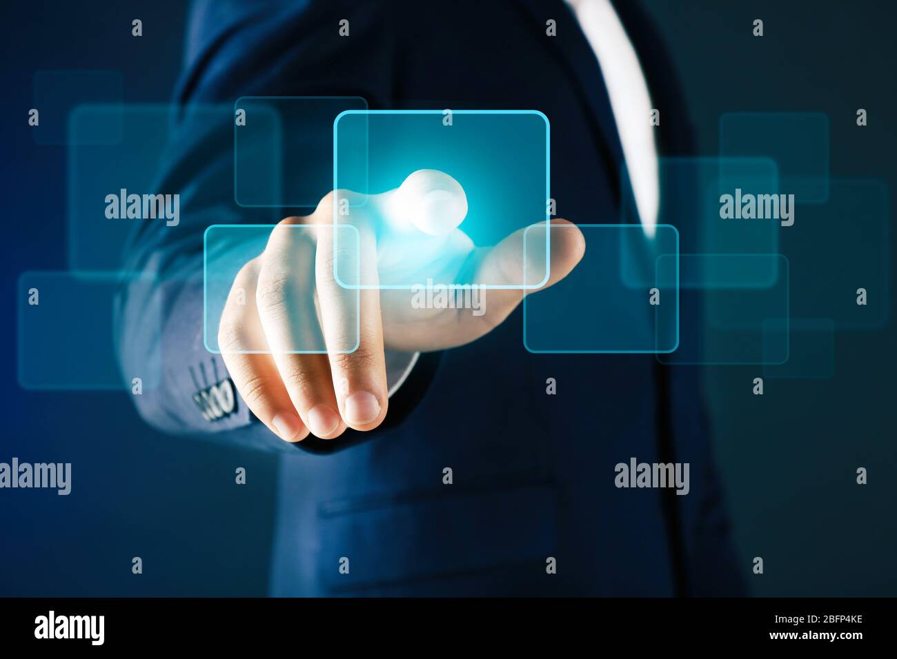 Businessman in suit pushing a button on virtual screen Stock Photo