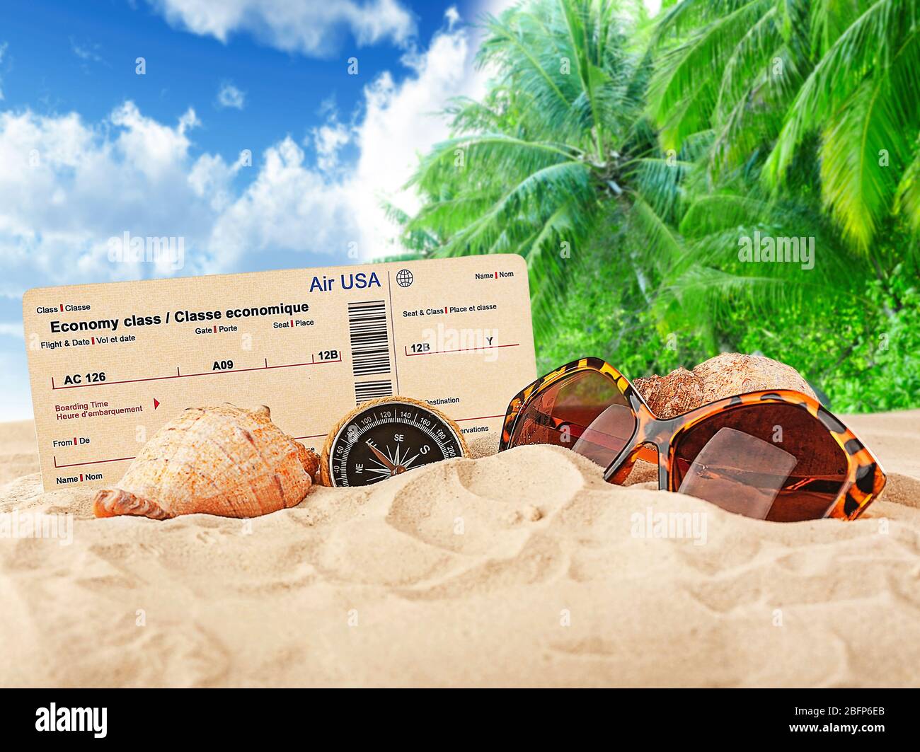 Boarding pass, shells, compass and sunglasses on beach. Tourism concept. Stock Photo