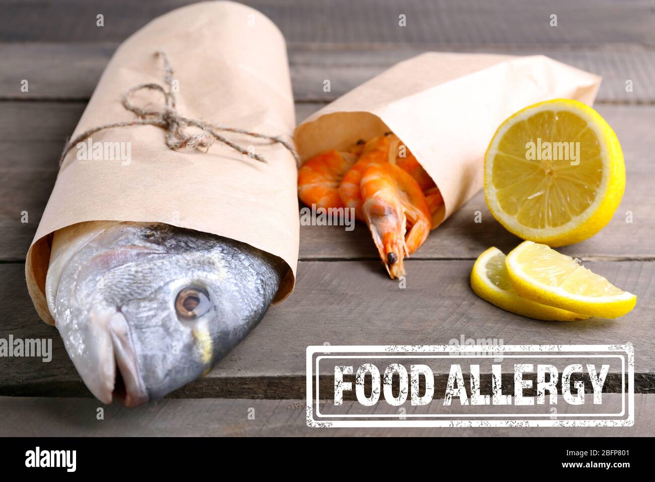 Allergy danger concept. Seafood with sliced lemon and stamp food allergy on wooden background. Stock Photo
