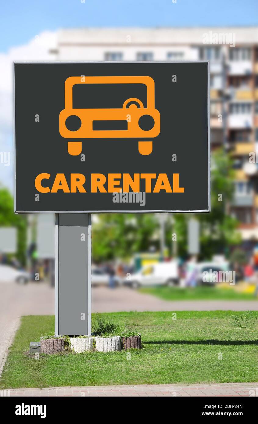Billboard with text car rental on city street. Stock Photo