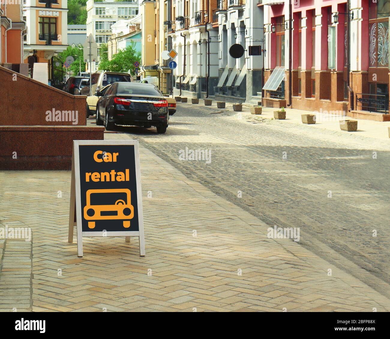 Billboard with text car rental on city street. Stock Photo