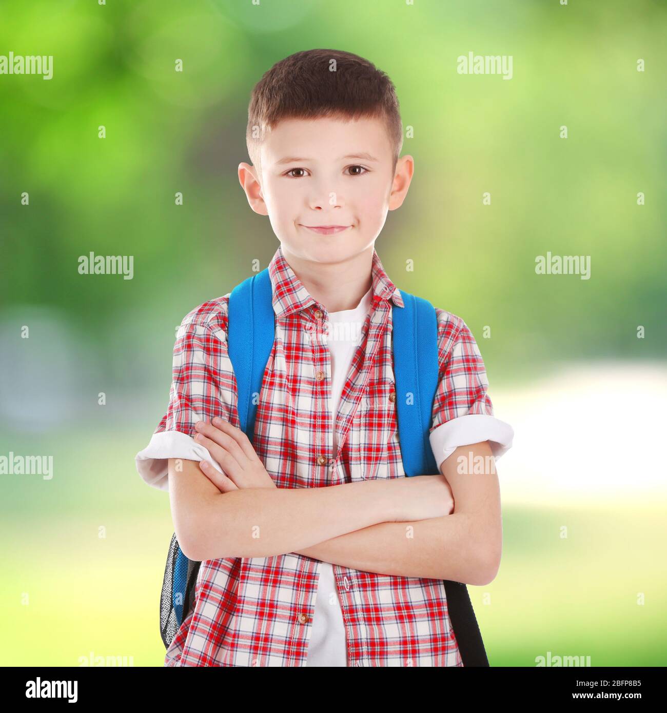 Cute boy with backpack on blurred green background. School concept ...