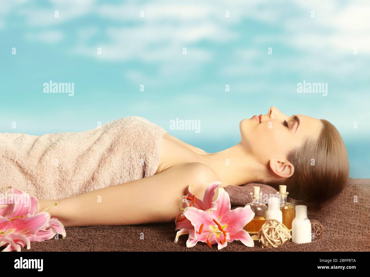 Spa concept. Beautiful woman having massage on table. Blurred blue  background Stock Photo - Alamy