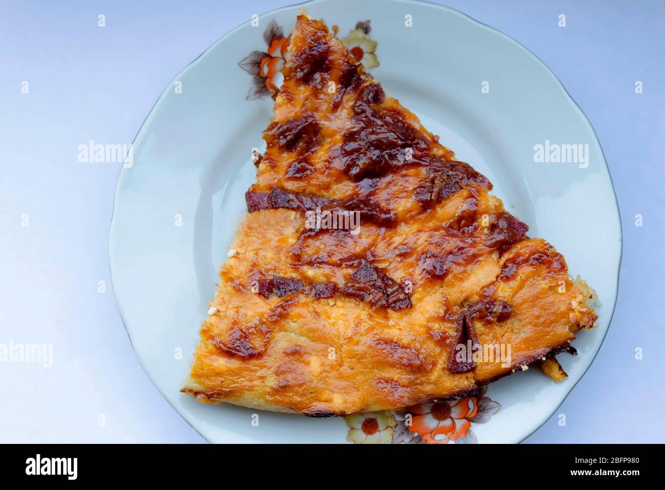 A slice of delicious pizza with vegetables, ham, cheese and  kashkaval  in plate, Sofia, Bulgaria, Europe Stock Photo