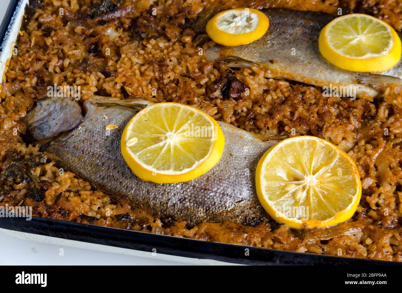 Roasted trout fish on rice and lemon slices on top, Sofia, Bulgaria Stock Photo