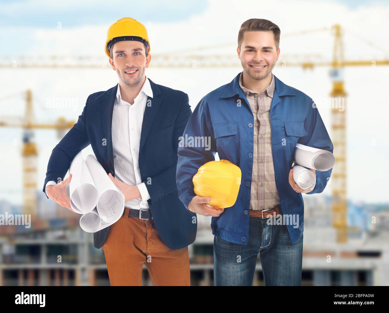 Professional engineers with blueprint on blurred city background Stock Photo