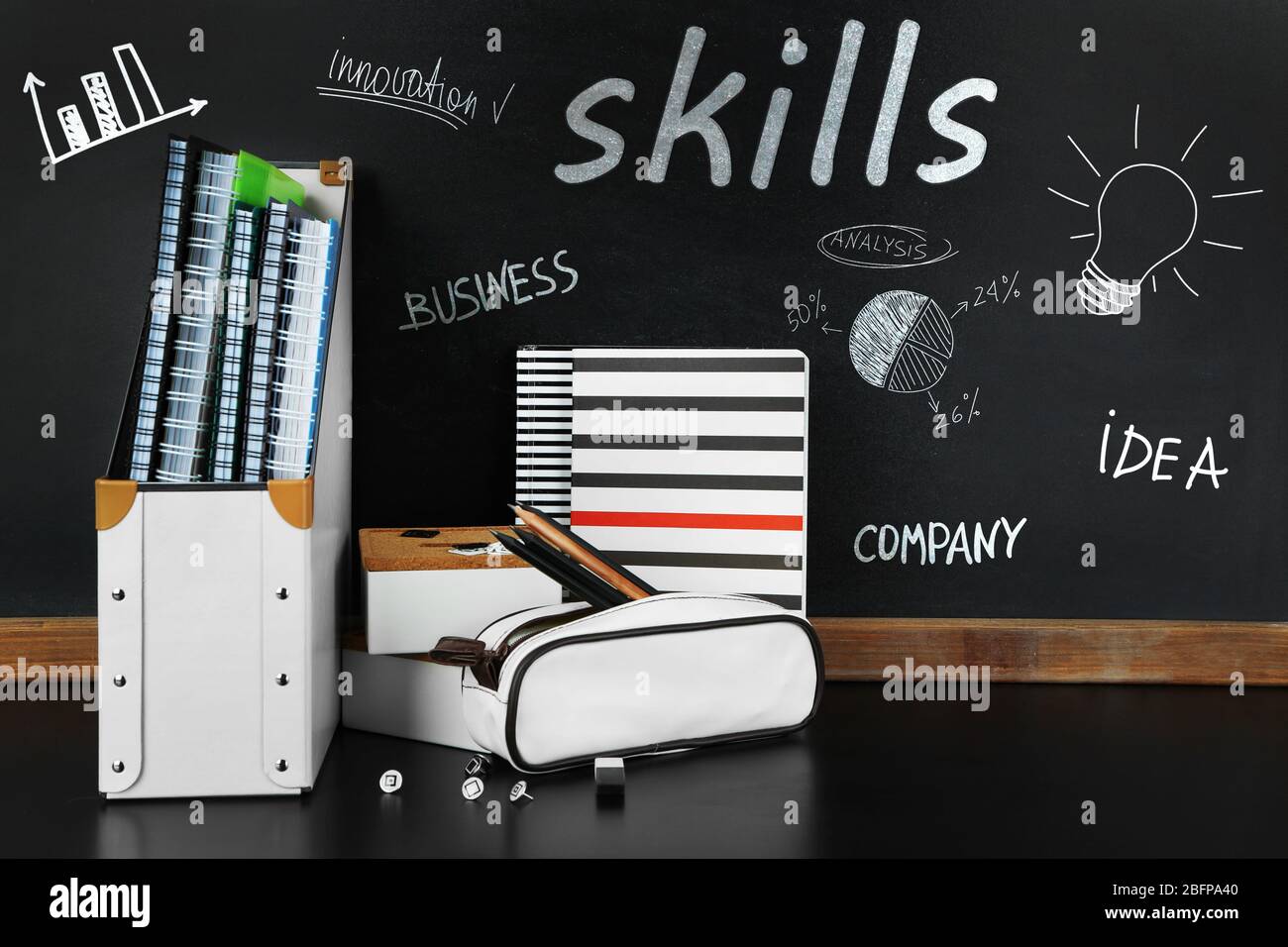 Skills. School supplies near blackboard, close up Stock Photo