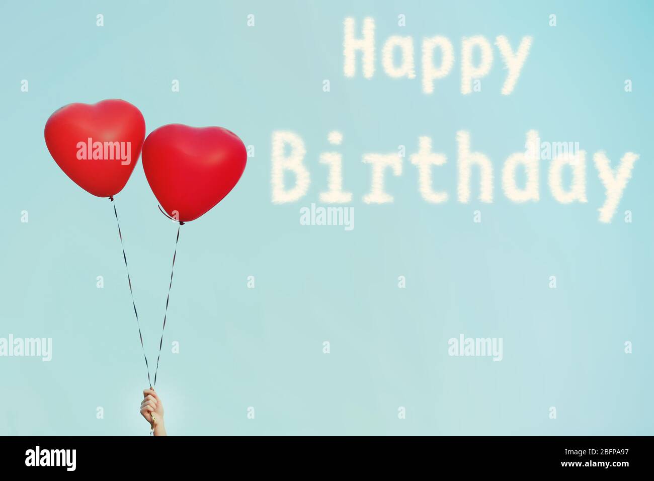 Happy Birthday text and love heart balloons on sky background Stock Photo -  Alamy