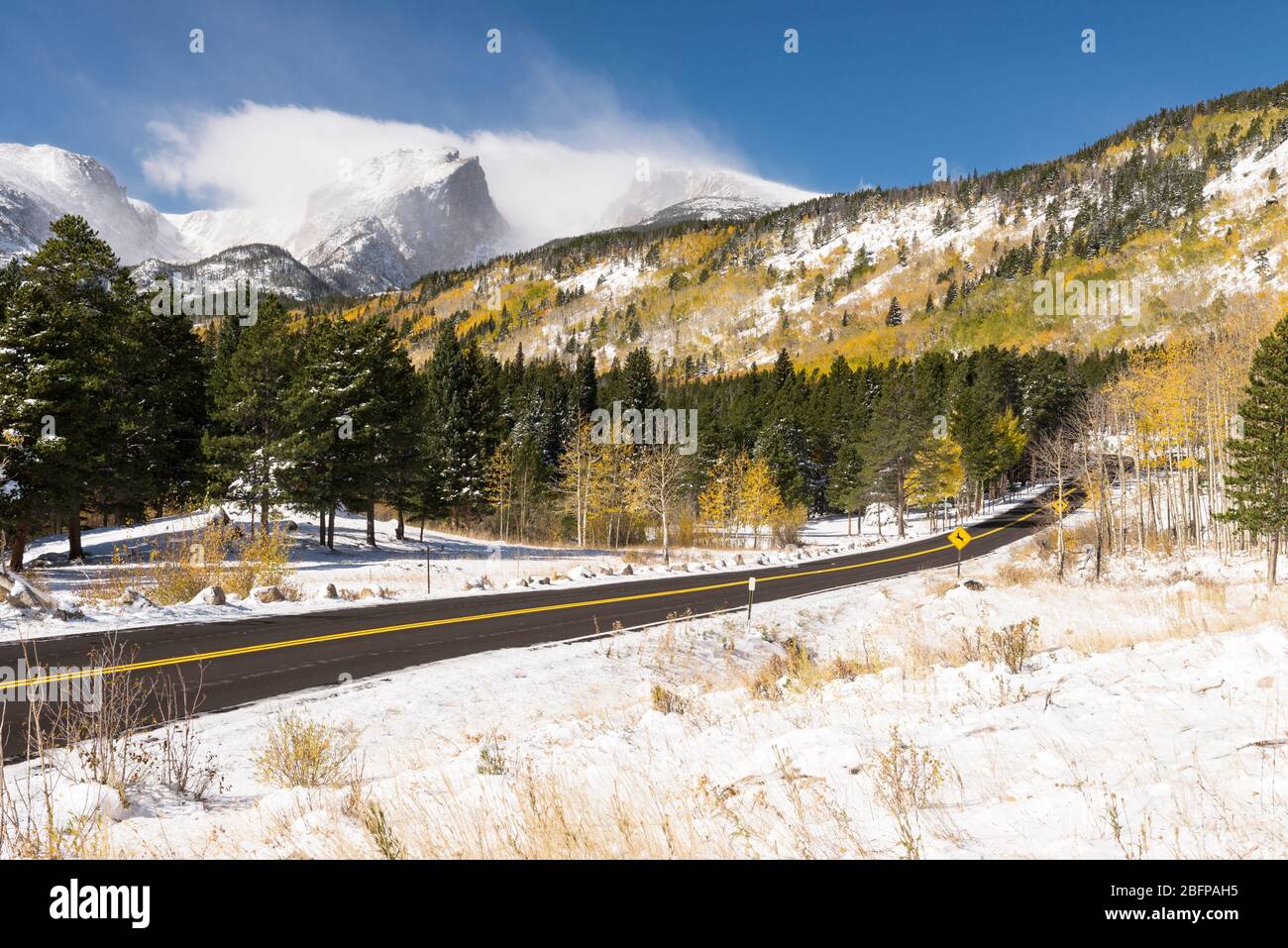 12,713 ft. Hallet Peak and 12,324 ft. Flattop Mountain a scenic paved road takes visitors through the rich scenery of an early autumn snow storm. Stock Photo
