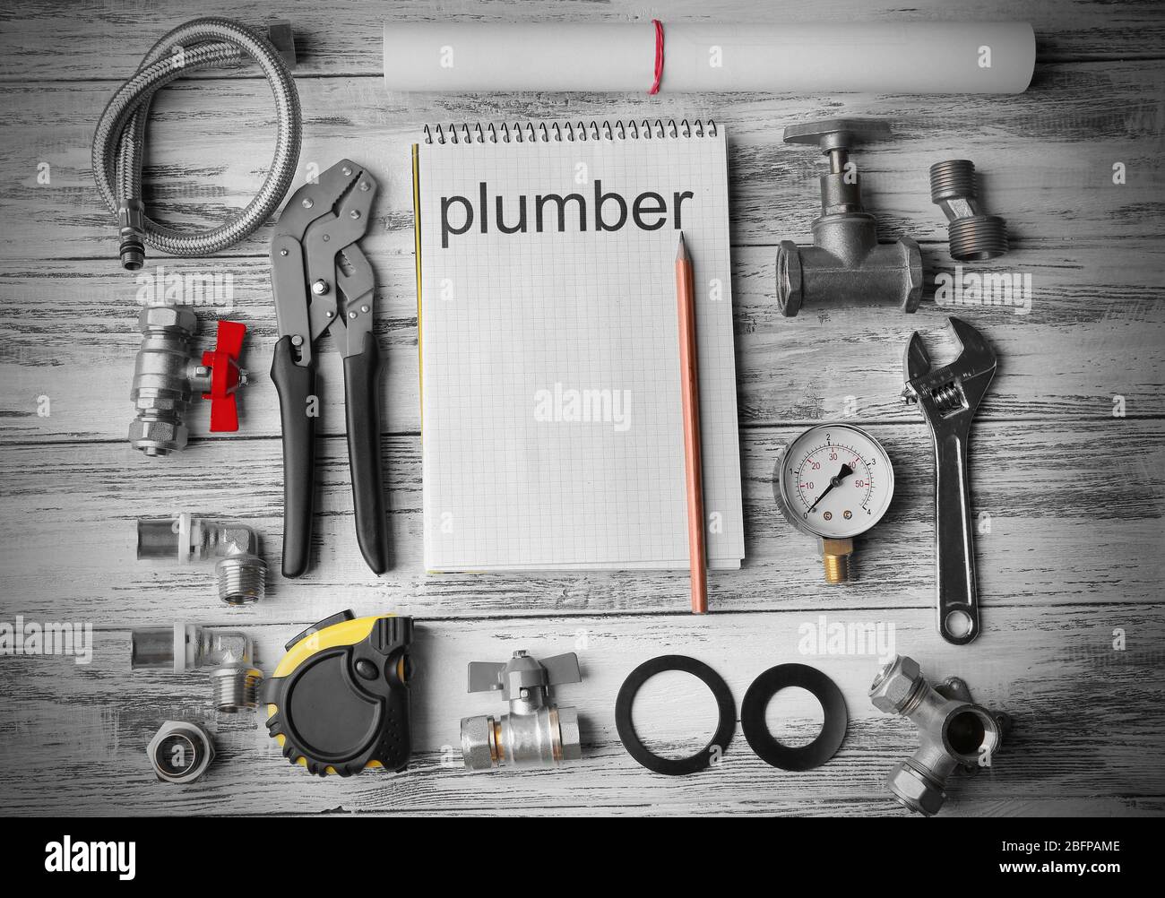 Plumbing concept. Plumber tools with notebook on wooden textured background Stock Photo