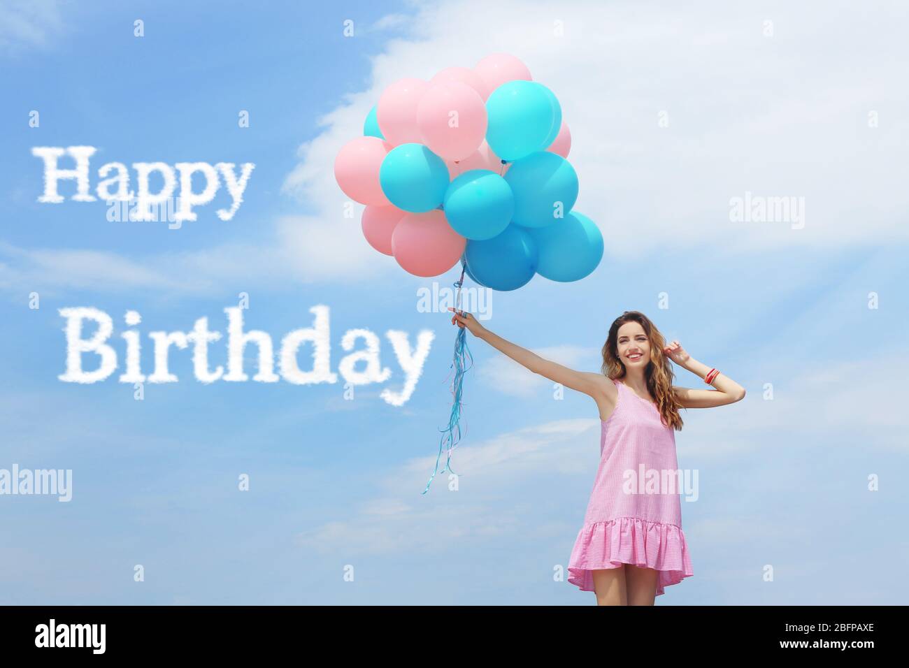 Happy Birthday text and beautiful young woman with colorful balloons  against blue sky Stock Photo - Alamy