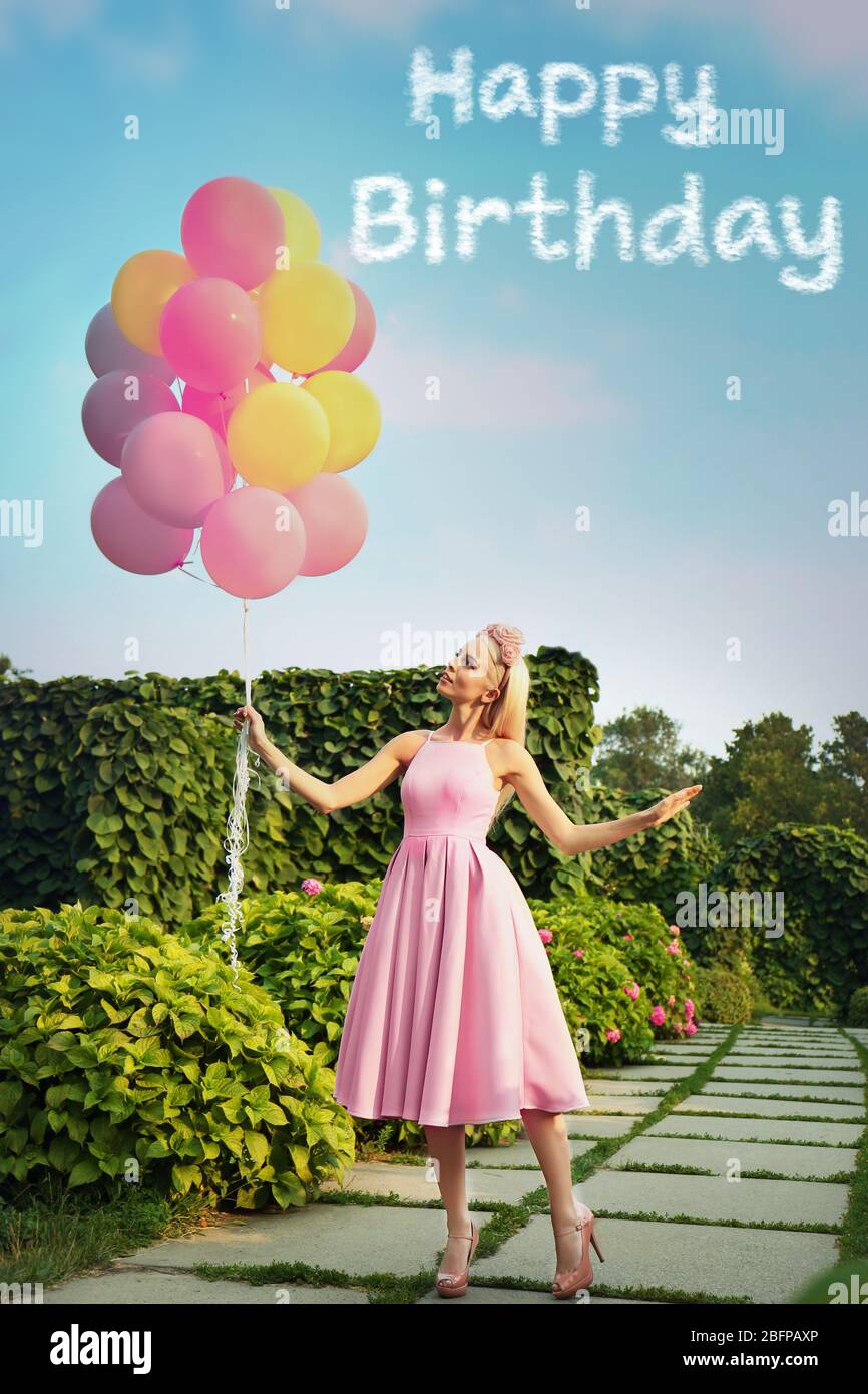 Happy Birthday text and beautiful young woman holding air balloons in