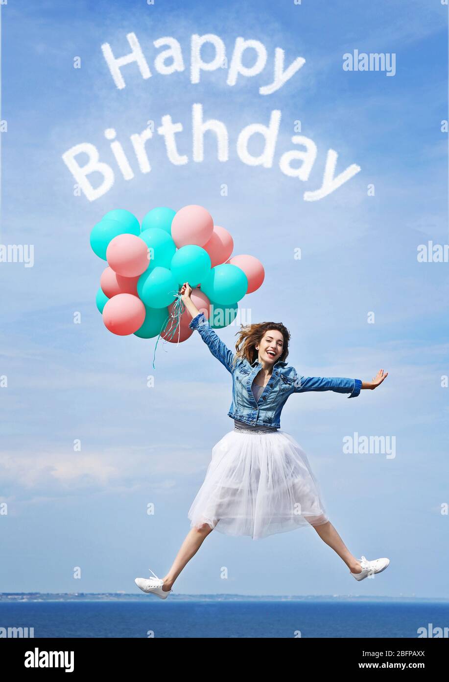 Happy Birthday text and beautiful young woman with colorful balloons  against blue sky Stock Photo - Alamy