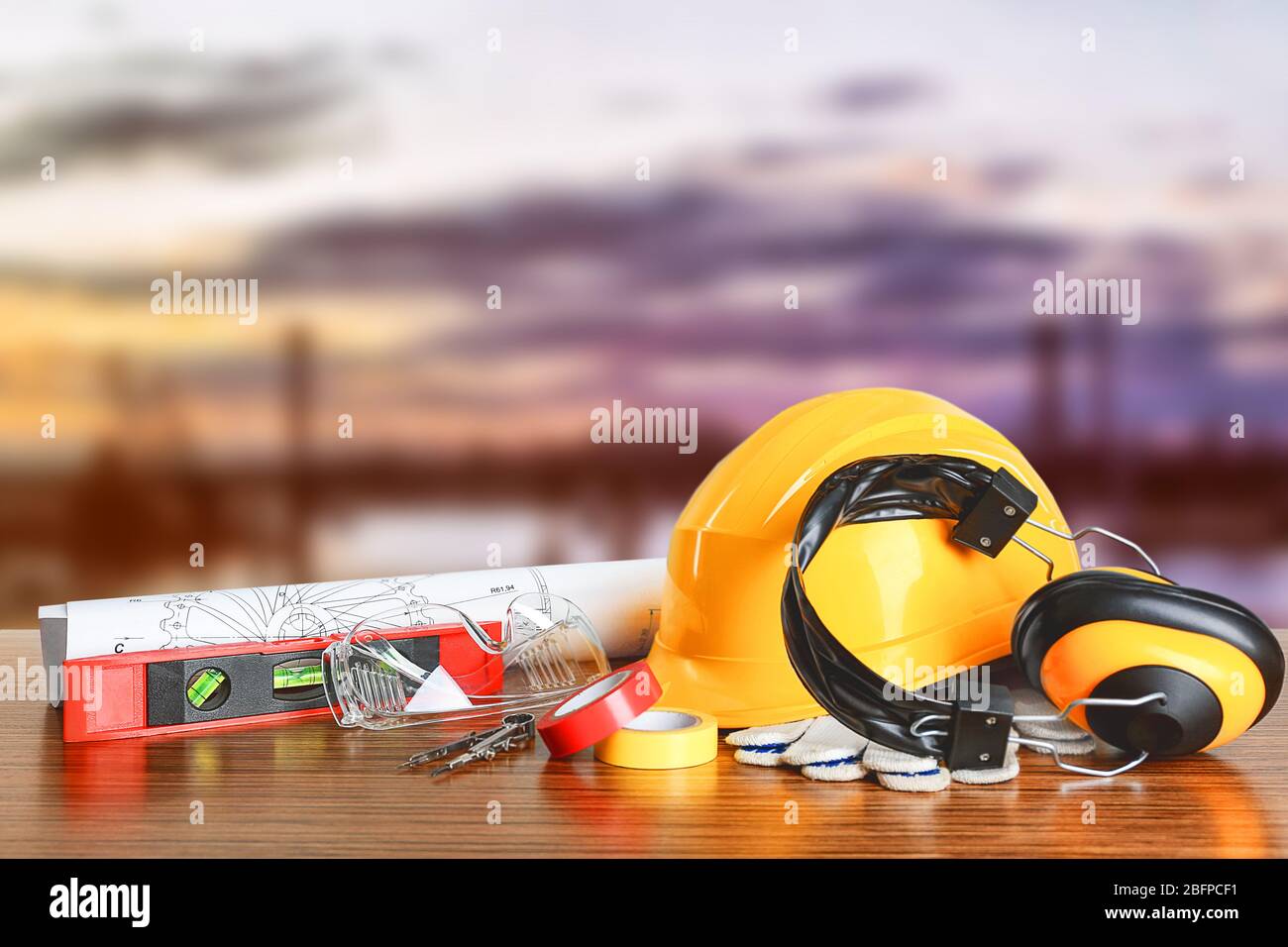 Construction blueprints with tools and helmet on sky background Stock Photo
